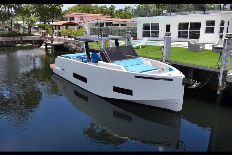  Yacht Photos Pics 2021 De Antonio Yachts Center Console docked by modern waterfront home.