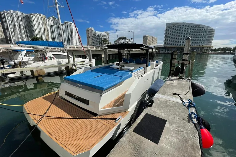  Yacht Photos Pics 2021 De Antonio Yachts Center Console docked in a marina with cityscape background.