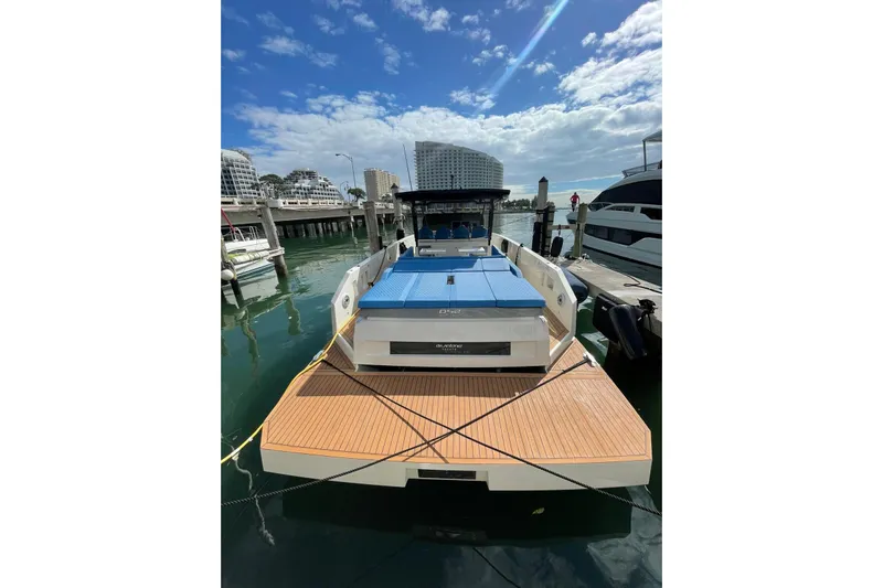  Yacht Photos Pics 2021 De Antonio Yachts Center Console docked at marina under blue sky.