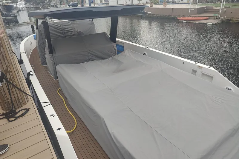  Yacht Photos Pics 2021 De Antonio Yachts Center Console covered, docked by a calm waterfront.