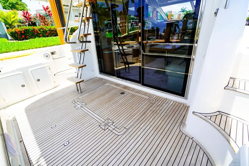 Queen Of Ark Yacht Photos Pics 2017 Azimut 42 Fly yacht deck with wooden flooring and glass doors.