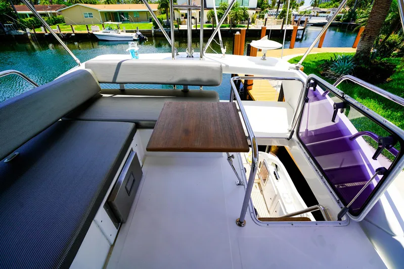 Queen Of Ark Yacht Photos Pics Flybridge of 2017 Azimut 42 Fly yacht with seating and table, overlooking waterway.