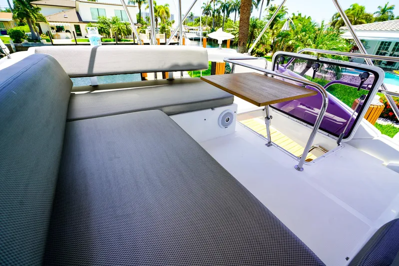 Queen Of Ark Yacht Photos Pics Azimut 42 Fly 2017 yacht flybridge with cushioned seating and table, surrounded by tropical scenery.