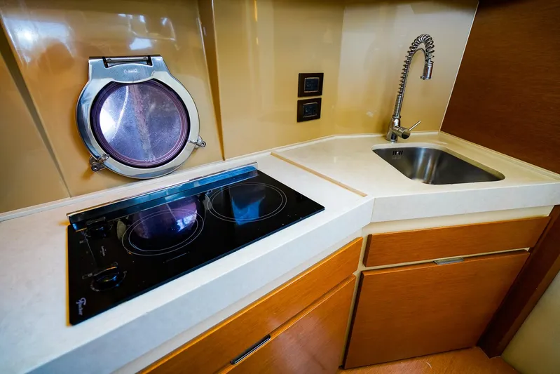 Queen Of Ark Yacht Photos Pics Modern kitchen in 2017 Azimut 42 Fly yacht with stove, sink, and porthole.