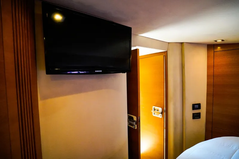 Queen Of Ark Yacht Photos Pics Interior of 2017 Azimut 42 Fly yacht with wall-mounted TV and wooden door.