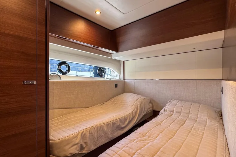  Yacht Photos Pics Luxurious twin cabin interior of 2019 Princess F55 yacht with wood paneling and soft lighting.