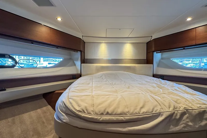  Yacht Photos Pics Luxurious bedroom interior of 2019 Princess F55 yacht with elegant wood accents and soft lighting.