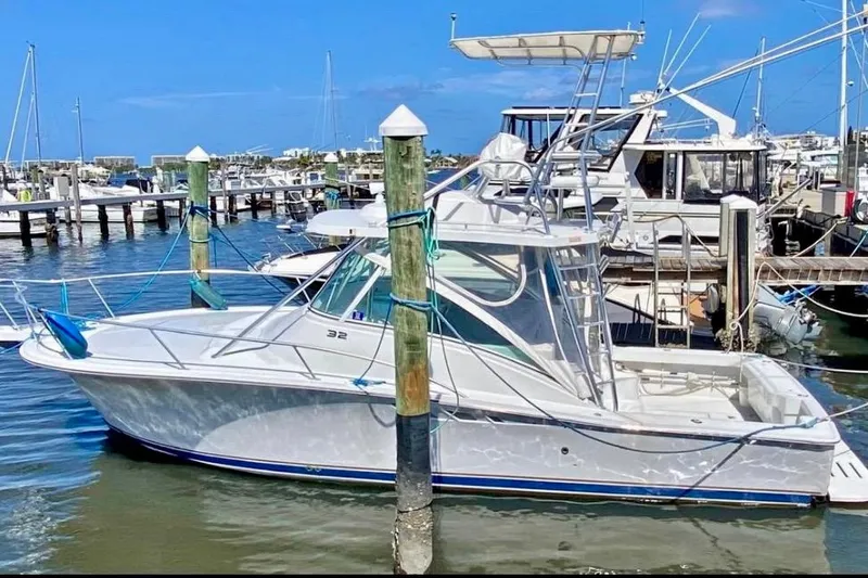  Yacht Photos Pics 2002 Luhrs 32 Open boat docked in a marina under clear blue skies.