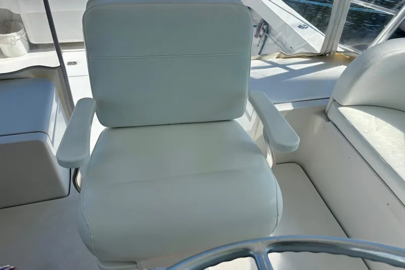  Yacht Photos Pics Captain's chair on 2002 Luhrs 32 Open boat, featuring white upholstery and armrests.