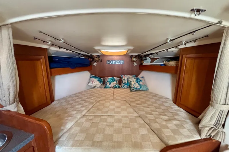  Yacht Photos Pics Cozy cabin interior of 2002 Luhrs 32 Open boat with decorative pillows and wooden storage.