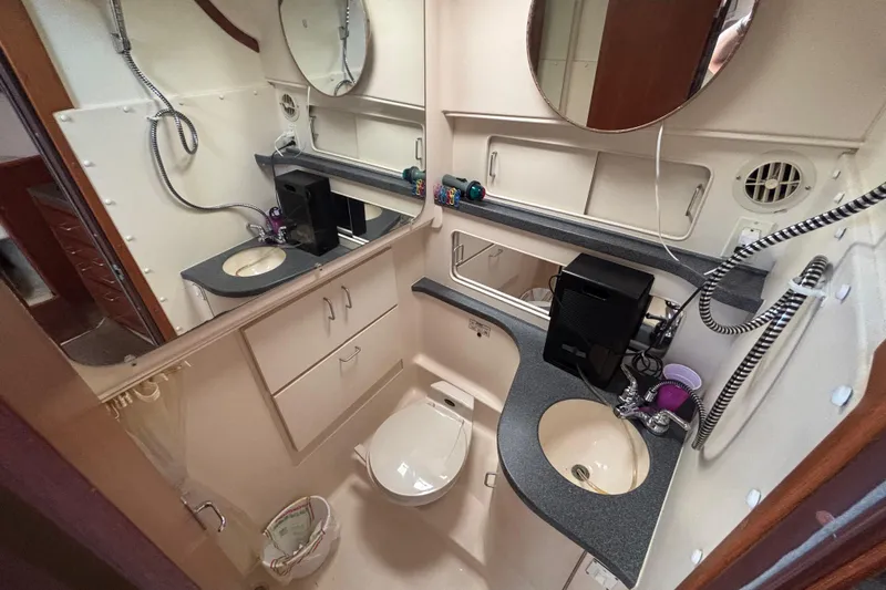  Yacht Photos Pics Bathroom interior of 2002 Luhrs 32 Open boat, featuring sink, toilet, and storage cabinets.