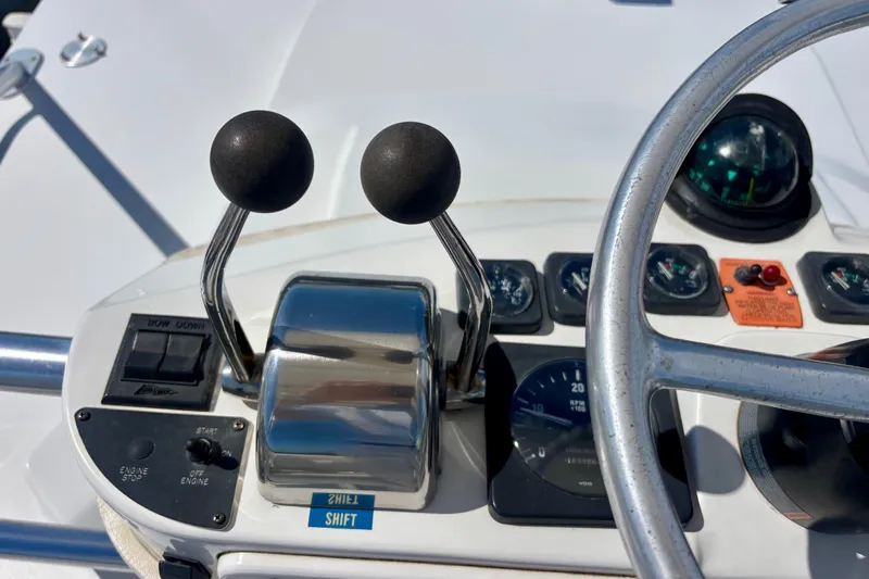  Yacht Photos Pics Control panel of a 2002 Luhrs 32 Open boat with steering wheel and throttle levers.