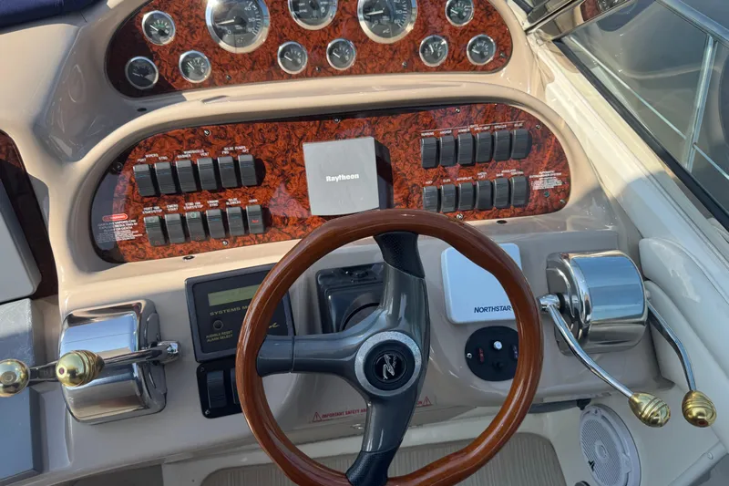  Yacht Photos Pics Control panel of a 2002 Sea Ray 360 Sundancer boat with steering wheel and gauges.