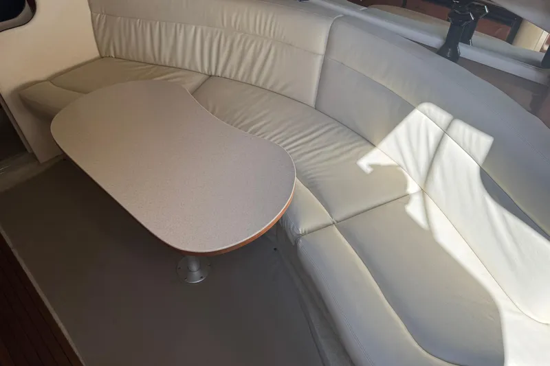  Yacht Photos Pics 2002 Sea Ray 360 Sundancer interior with curved leather seating and oval table.