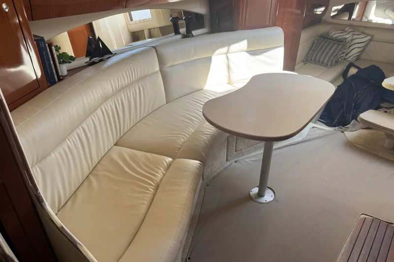  Yacht Photos Pics Interior of 2002 Sea Ray 360 Sundancer with cream leather seating and wooden table.