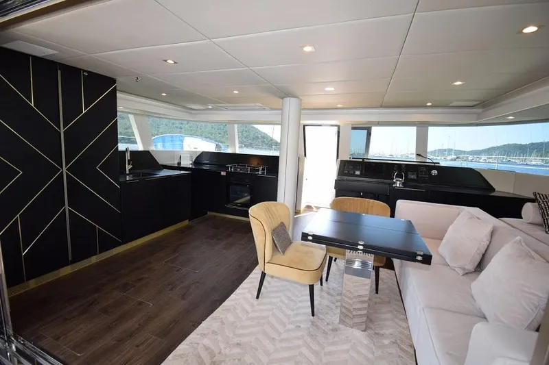 Welcome Back Yacht Photos Pics Luxurious interior of 2019 Sunreef 50 yacht with modern furnishings and panoramic windows.