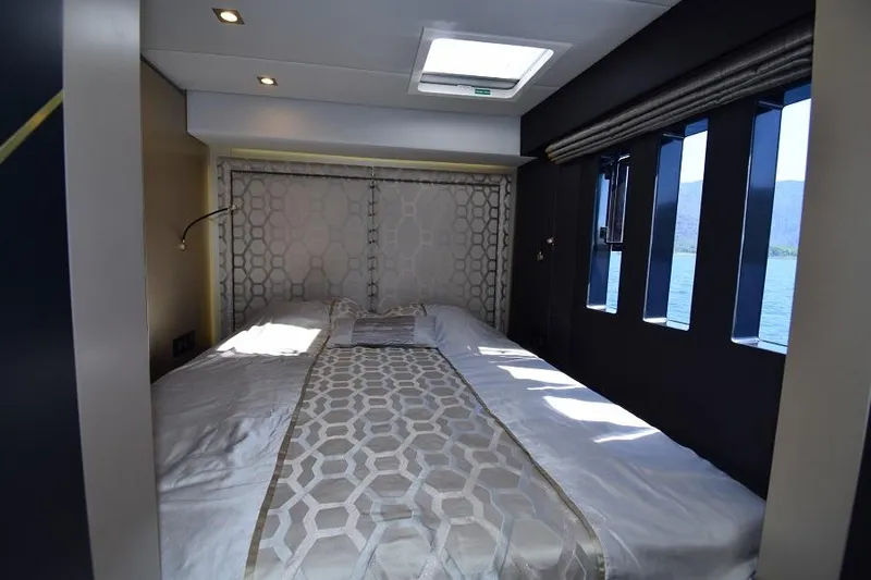 Welcome Back Yacht Photos Pics Luxurious bedroom interior of 2019 Sunreef 50 yacht with elegant bedding and scenic window view.