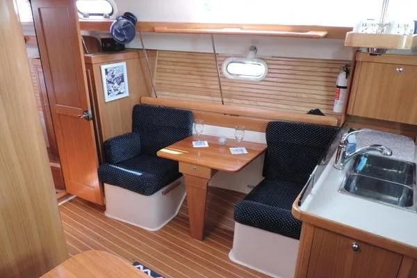 Eighth Day Yacht Photos Pics Interior of 2008 Catalina 350 MkII sailboat with dining area and kitchenette.