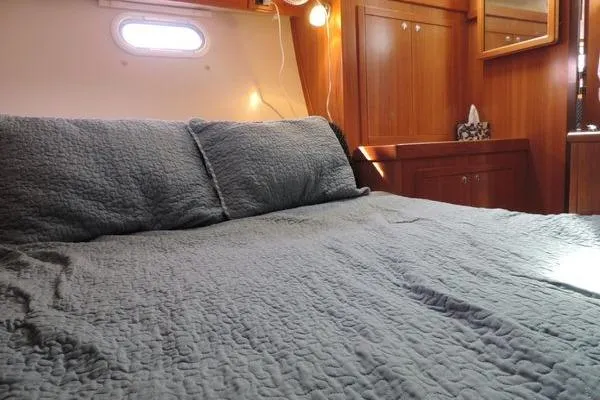 Eighth Day Yacht Photos Pics Cozy cabin interior of 2008 Catalina 350 MkII with quilted bedding and wooden cabinetry.
