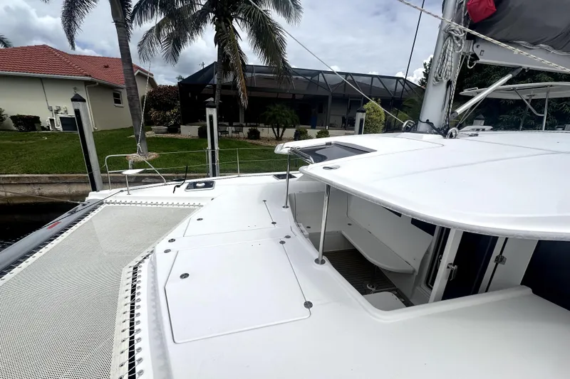  Yacht Photos Pics 2016 Leopard 44 catamaran docked near a waterfront home with palm trees.