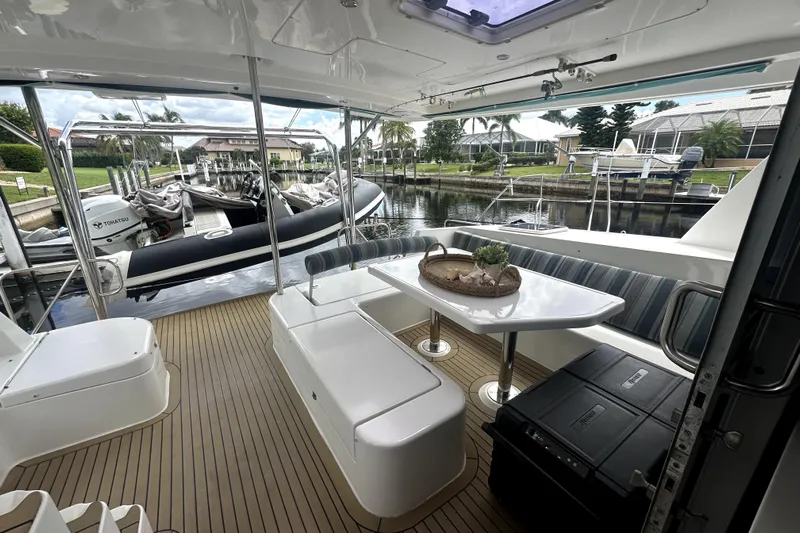  Yacht Photos Pics Spacious deck of 2016 Leopard 44 yacht with seating and table, docked by waterfront.