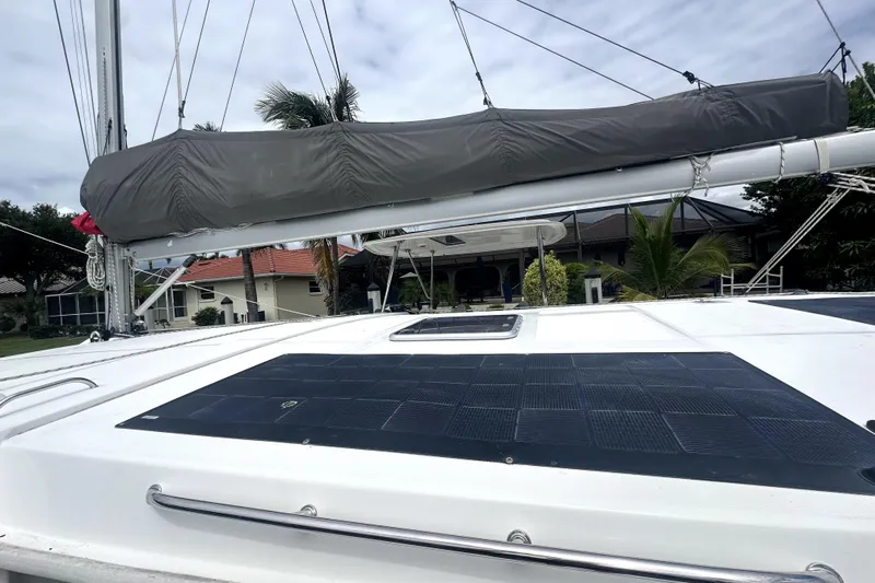  Yacht Photos Pics 2016 Leopard 44 catamaran with solar panels and covered sail, docked near tropical foliage.