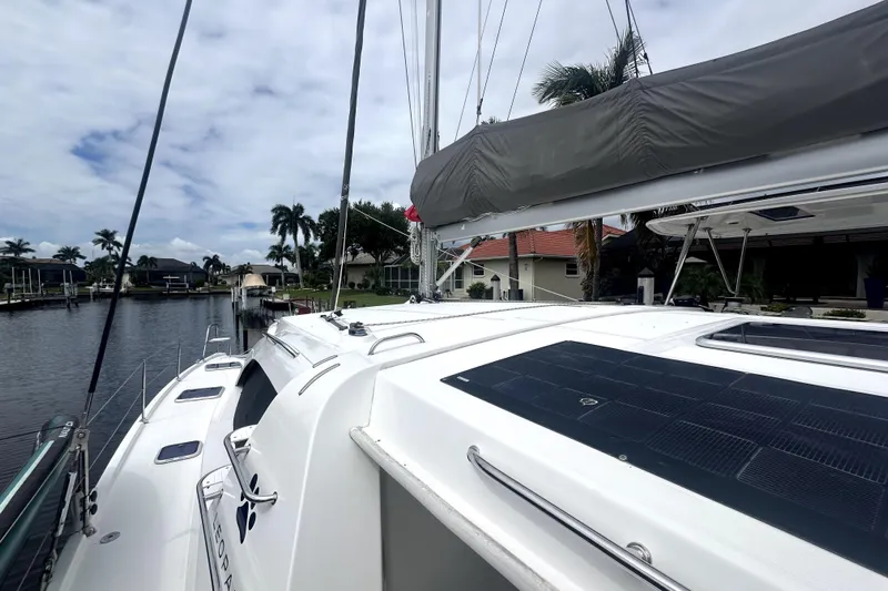  Yacht Photos Pics 2016 Leopard 44 catamaran docked by waterfront homes, featuring solar panels and palm trees.