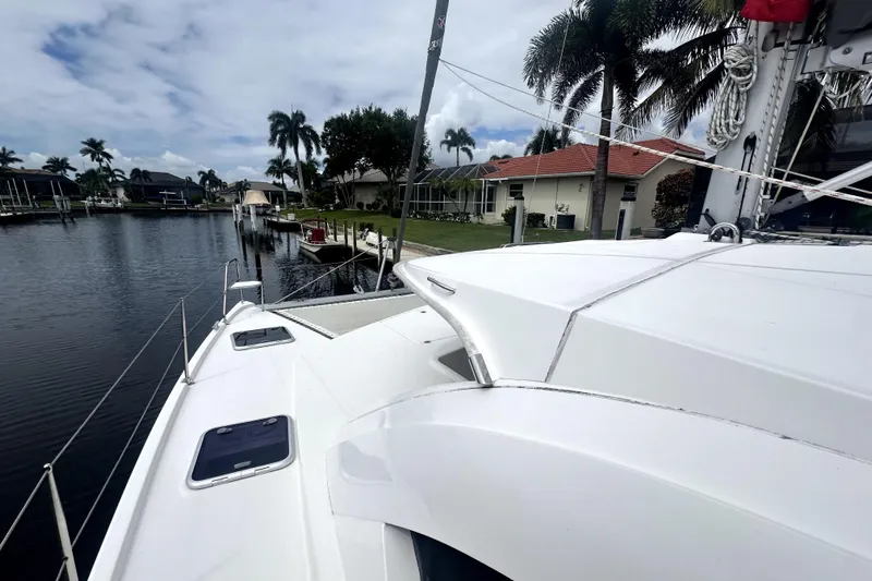  Yacht Photos Pics 2016 Leopard 44 catamaran docked by waterfront homes with palm trees.