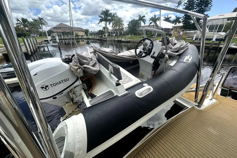  Yacht Photos Pics Inflatable boat with Tohatsu motor on Leopard 44, 2016 model, docked by palm trees.