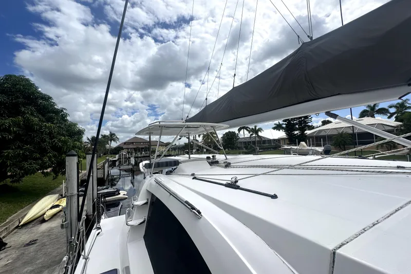  Yacht Photos Pics 2016 Leopard 44 catamaran docked, showcasing sleek design and spacious deck under cloudy sky.