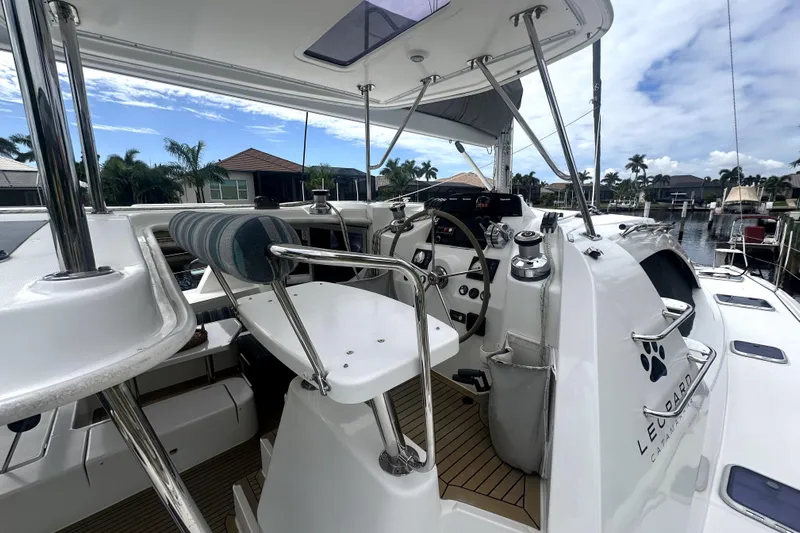  Yacht Photos Pics Helm of 2016 Leopard 44 catamaran with modern controls and seating, docked in a marina.