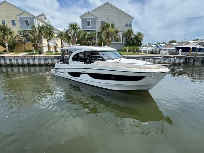  Yacht Photos Pics 2024 Beneteau Antares 11 boat docked near waterfront homes.