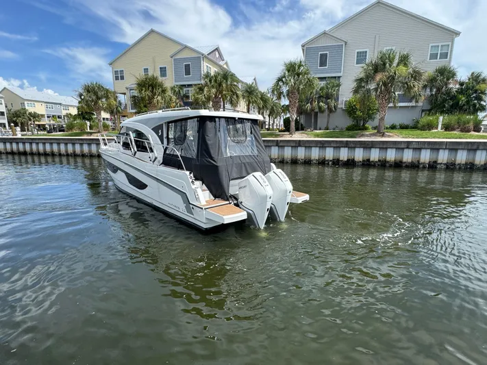  Yacht Photos Pics 2024 Beneteau Antares 11 boat on water near waterfront homes.
