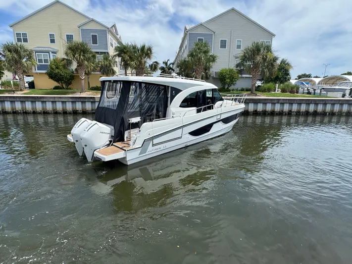  Yacht Photos Pics 2024 Beneteau Antares 11 boat docked near waterfront homes.
