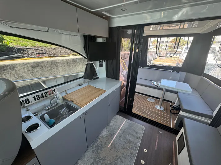  Yacht Photos Pics 2024 Beneteau Antares 11 interior with kitchenette, seating area, and modern design.