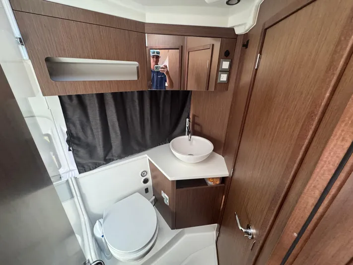  Yacht Photos Pics 2024 Beneteau Antares 11 bathroom with modern fixtures and wood accents.