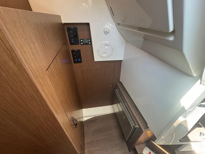  Yacht Photos Pics 2024 Beneteau Antares 11 interior with wood paneling and control panels.