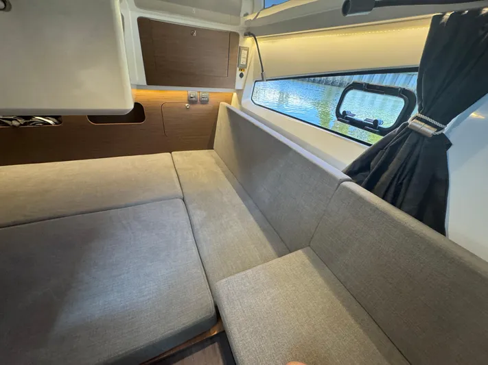  Yacht Photos Pics 2024 Beneteau Antares 11 interior with gray seating and window view.