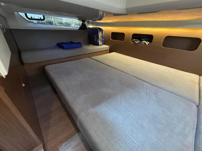  Yacht Photos Pics 2024 Beneteau Antares 11 cabin interior with cozy bedding and modern design.