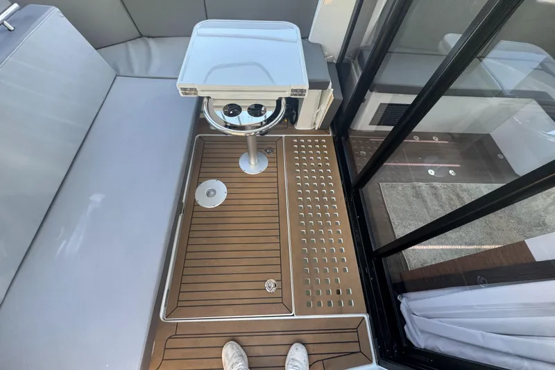  Yacht Photos Pics 2024 Beneteau Antares 11 interior with sleek seating, wooden flooring, and modern table design.