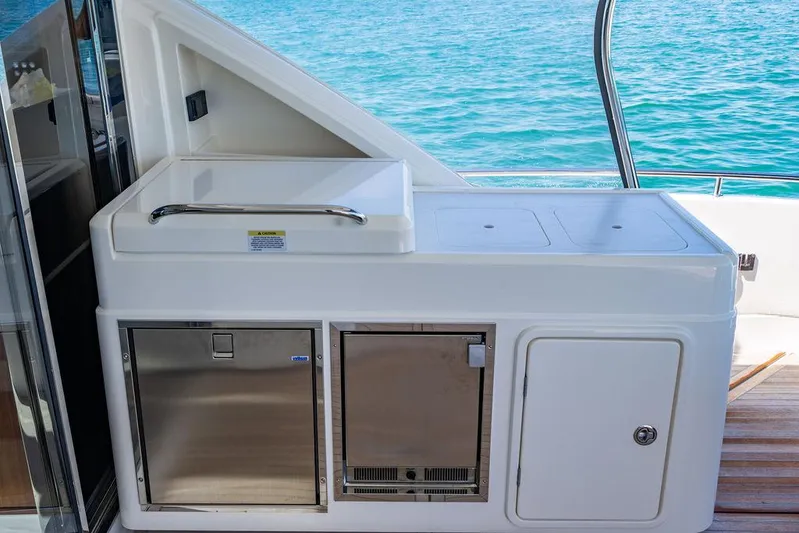 Bald Eagle Yacht Photos Pics Outdoor kitchenette on 2024 Riviera 6000SY yacht with stainless steel appliances and ocean view.