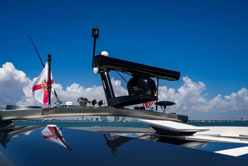 Bald Eagle Yacht Photos Pics 2024 Riviera 6000SY yacht with radar and flag against a clear blue sky.