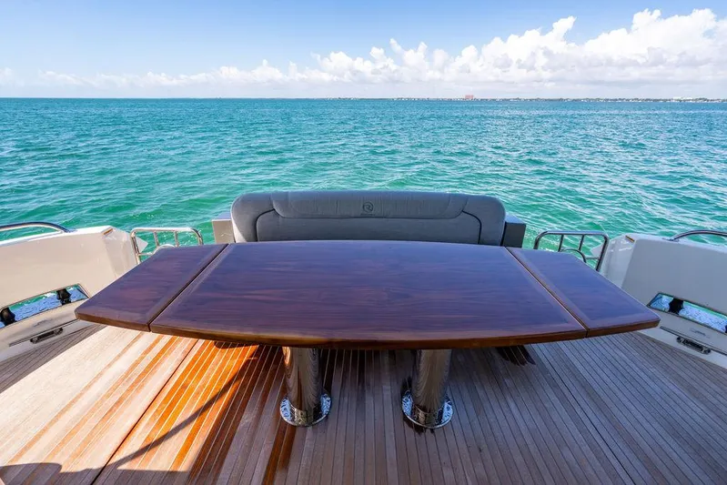 Bald Eagle Yacht Photos Pics Luxury Riviera 6000SY yacht deck with wooden table, ocean view, 2024 model.