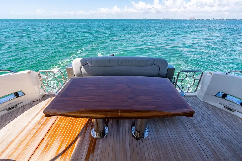 Bald Eagle Yacht Photos Pics 2024 Riviera 6000SY yacht deck with wooden table, overlooking the ocean.