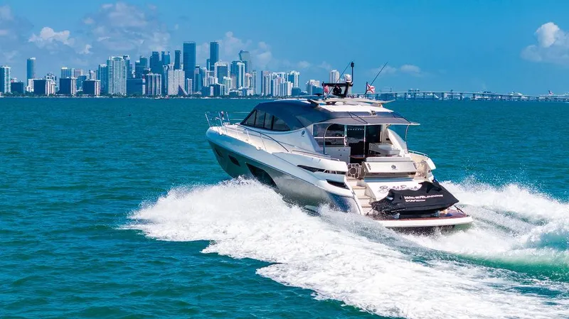 Bald Eagle Yacht Photos Pics 2024 Riviera 6000SY yacht cruising near a city skyline on a sunny day.