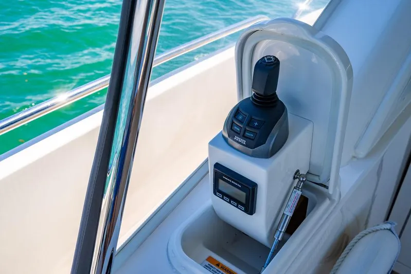 Bald Eagle Yacht Photos Pics 2024 Riviera 6000SY yacht control panel with joystick and display, overlooking blue water.