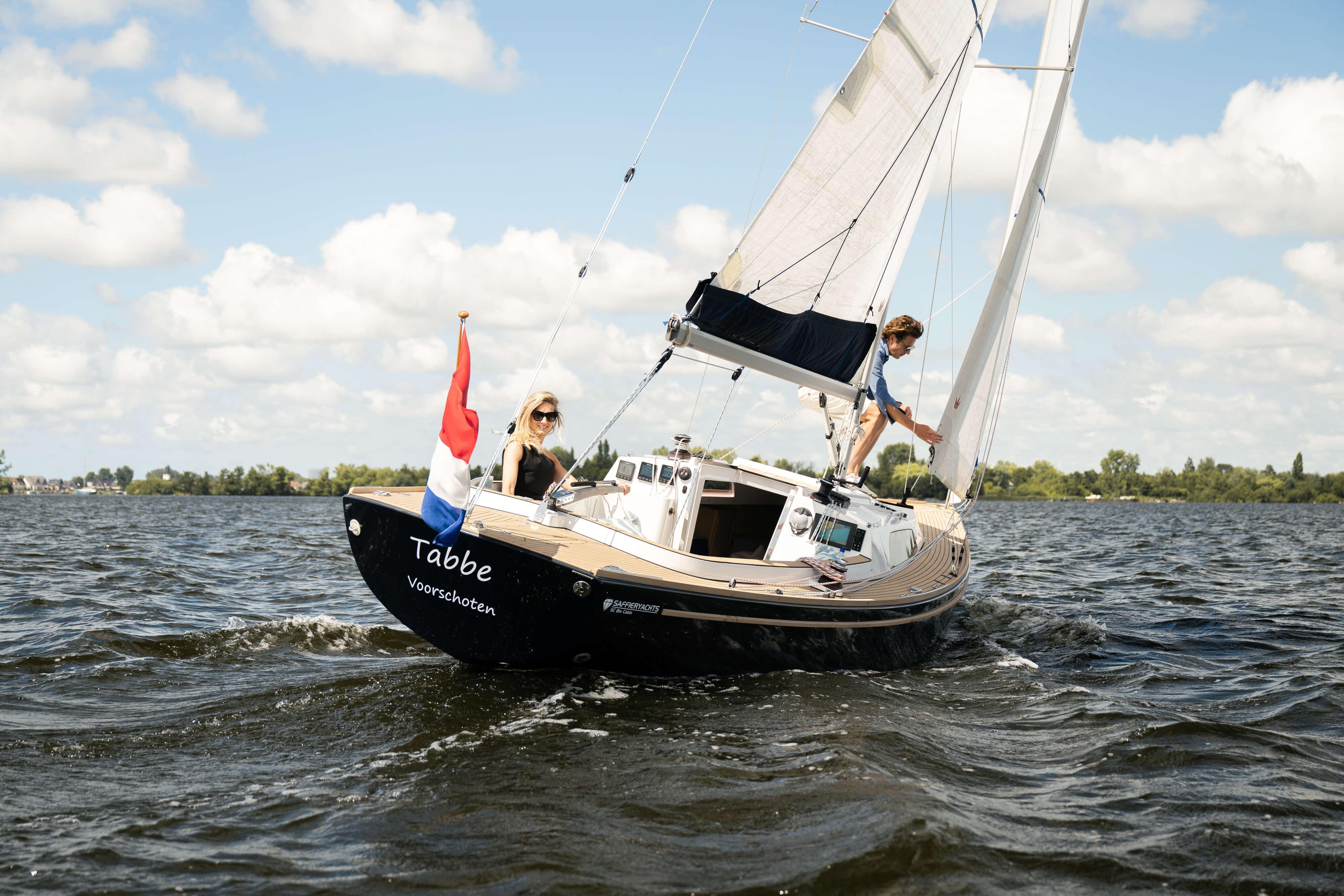Saffier SC 8M Cabin 2026 sailing on a lake under a clear blue sky.