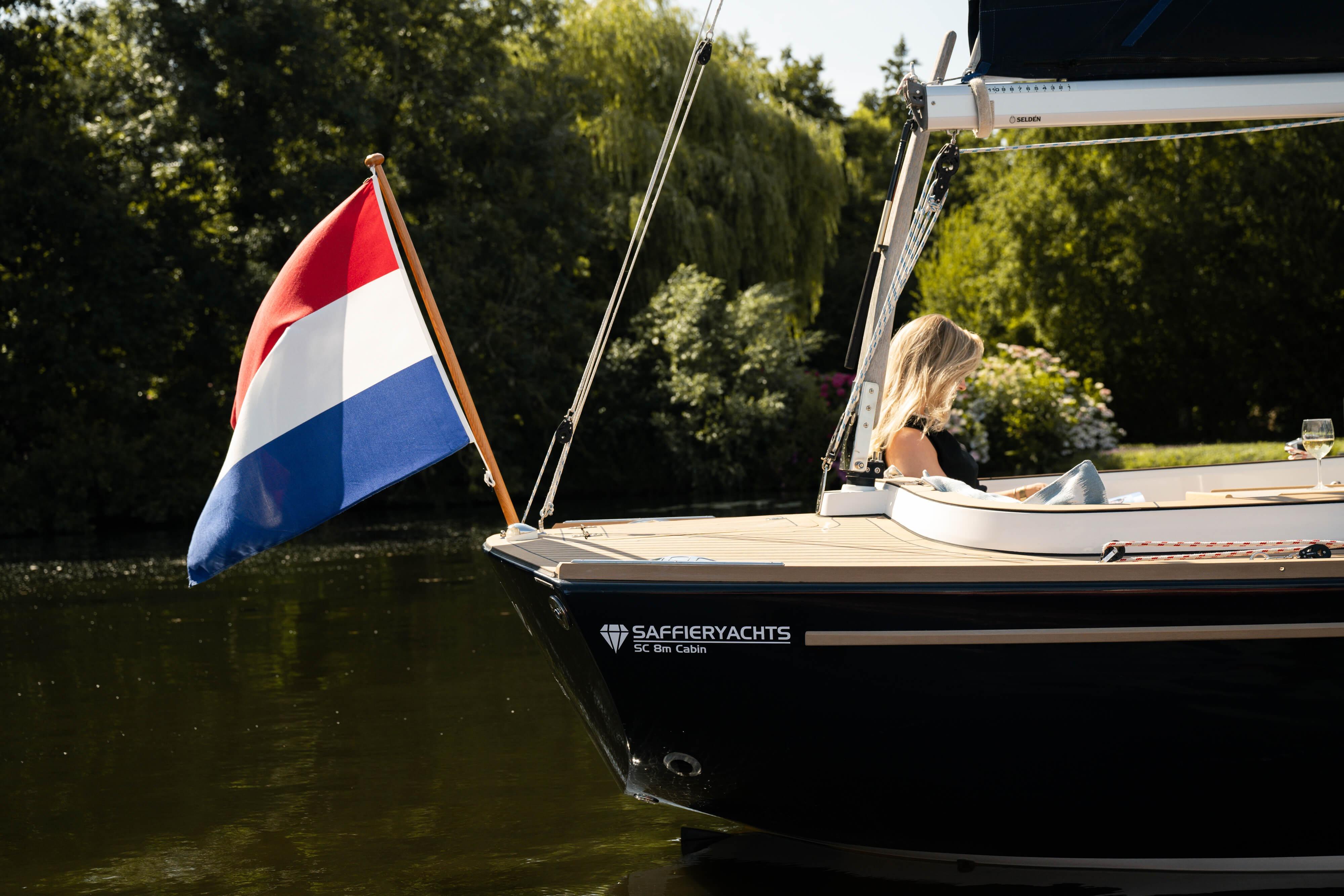 2026 Saffier SC 8M Cabin yacht with Dutch flag on tranquil water.