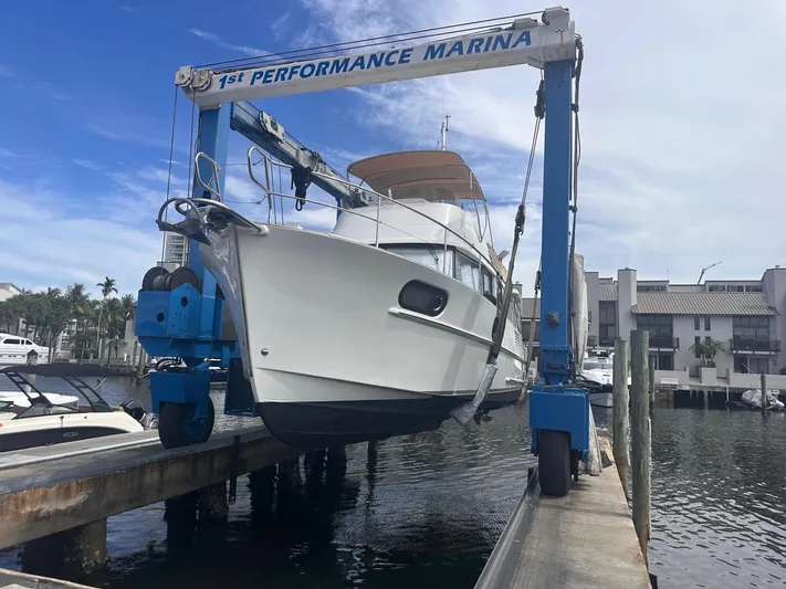 Beluga Yacht Photos Pics 2019 Beneteau Swift Trawler 44 being lifted at marina, clear sky background.