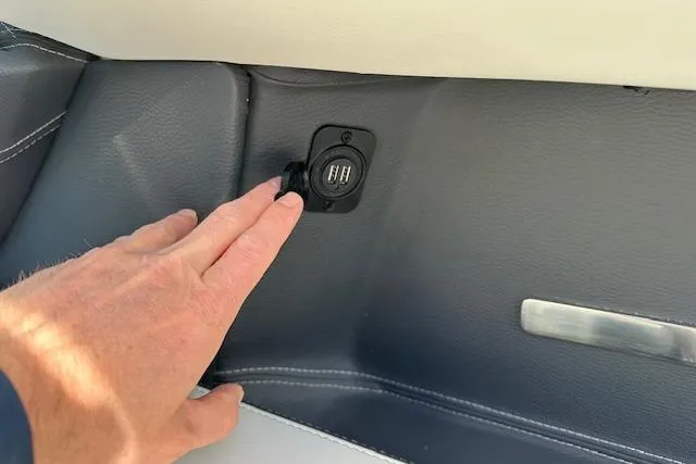  Yacht Photos Pics Hand touching USB port on 2023 Regal 2800 Bowrider boat interior.